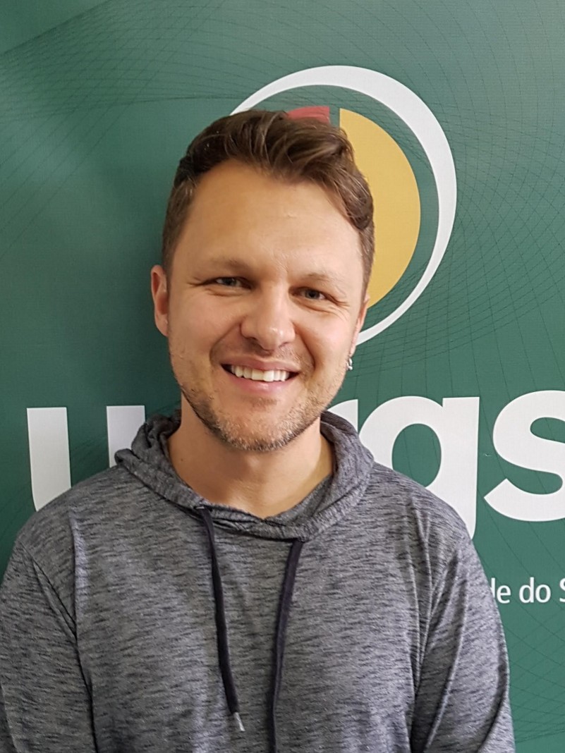 Homem de pele, olhos e cabelos claros, com uma barba rala.