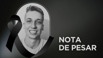 Imagem em preto e branco, com fundo preto. À esquerdam a foto de um jovem sorridente, branco de cabelos curtos. Sobre a foto, um laço preto. À direita, lê-se "Nota de Pesar".