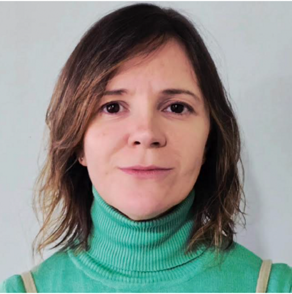 Mulher branca, com um leve sorriso e cabelo castanho curto.