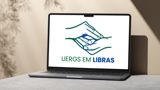Na tela de um notebook, sobre fundo branco, o s&iacute;mbolo da Uergs na L&iacute;ngua Brasileira de Sinais e, abaixo dele, a informa&ccedil;&atilde;o "Uergs em Libras", nas cores verde e azul.