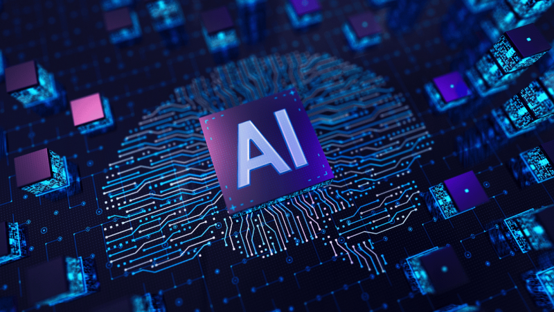 Imagem de um microchip com as letras &ldquo;AI&rdquo; em destaque, conectado a circuitos eletr&ocirc;nicos luminosos em tons de azul, roxo e rosa, sobre uma placa de tecnologia, assemelhando-se a um c&eacute;rebro humano. Ao redor, h&aacute; outros componentes eletr&ocirc;nicos, representando a intelig&ecirc;ncia artificial e a tecnologia digital
